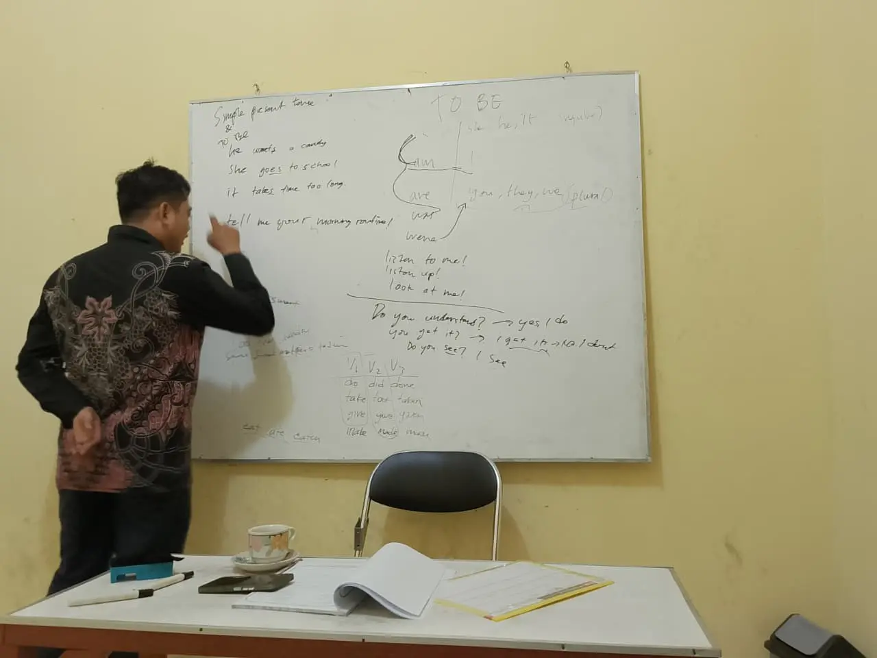 Guru SEC menjelaskan materi di papan tulis